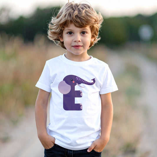 Boy wearing a white cotton t shirt with the letter E in the shape of an elephant illustration, hands in pocket