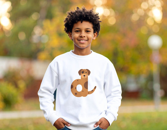 A teenage boy wearing a white crewneck sweatshirt with the letter D in the shape of a dog illustration, standing, blurry autumn background.