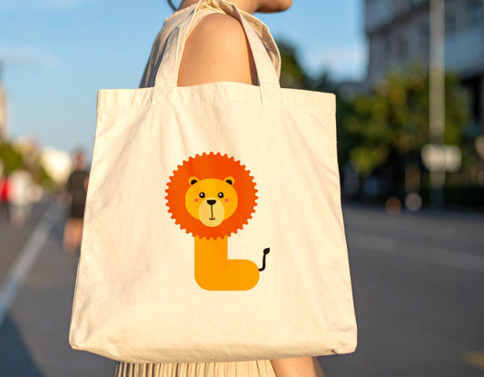 A woman carrying an oyster tote bag with the letter L in the shape of a lion illustration on a blurred city street background, sunset.